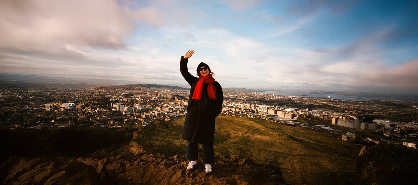 Woman with red scarf weaving at camera