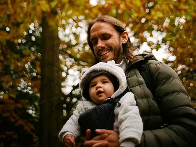 Man carrying a child in nature